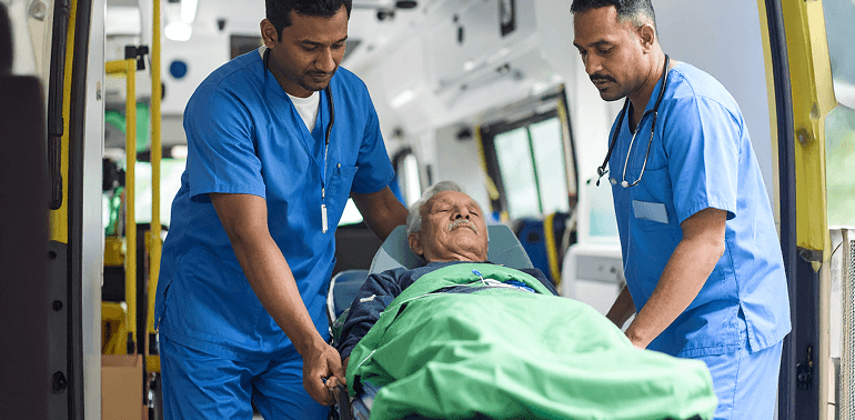 Paramedics helping elderly patient