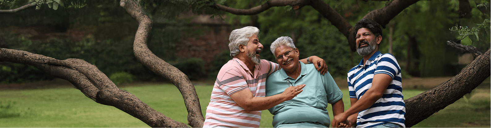 Elderly men laughing together in a park.