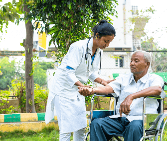 Nurse assisting man in wheelchair outdoors