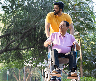Man pushing elderly man in wheelchair