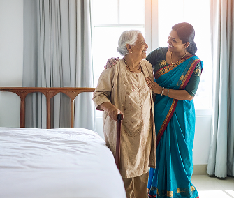 Caregiver supporting woman with cane